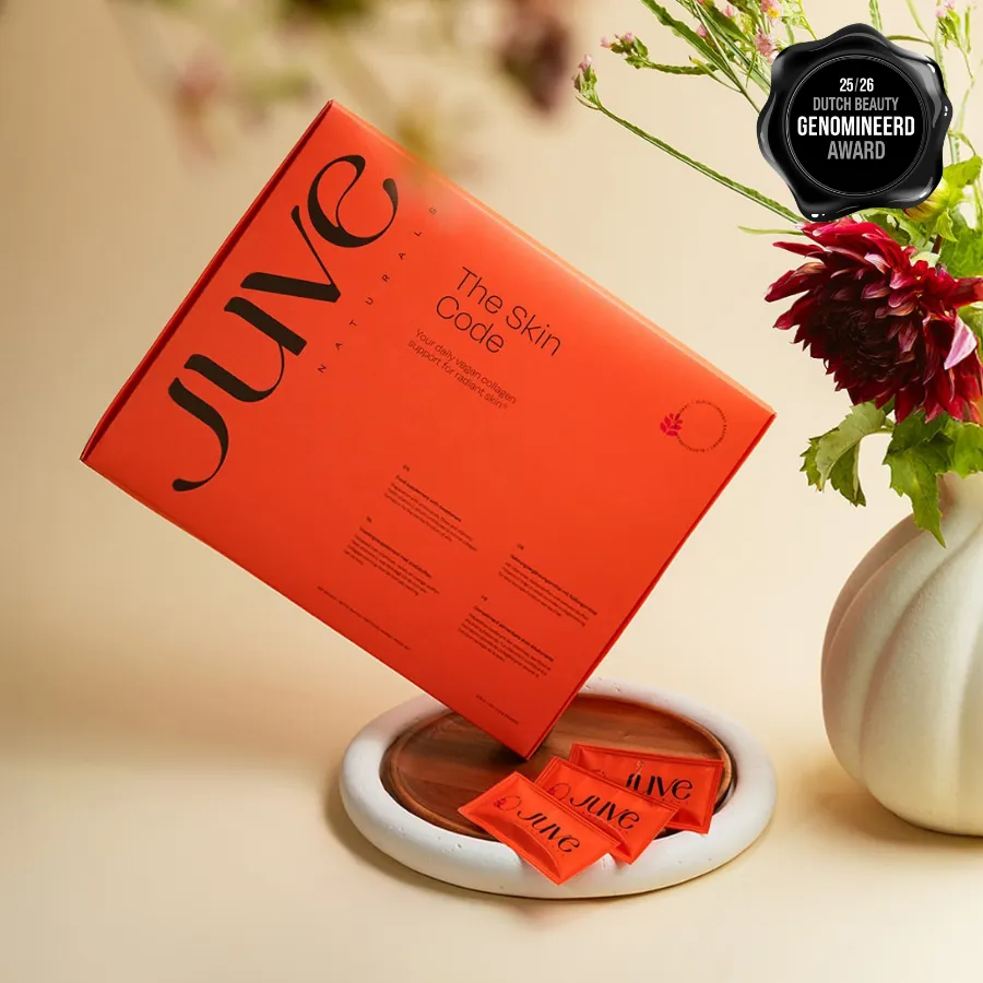 JuveNaturals skincare pack and sachets styled on a pale surface beside dried flowers